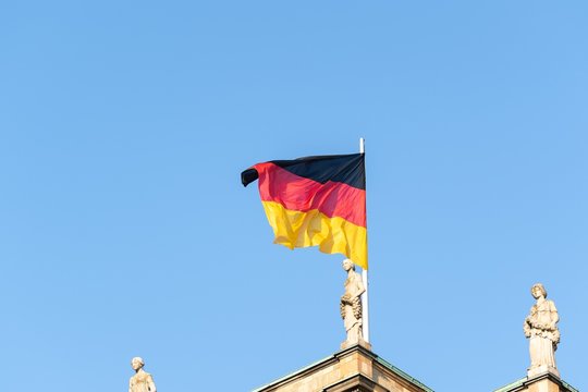 Flag of Germany flaunting on the wind under a blue sky