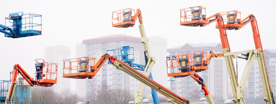 Access platform equipment powered high in sky in blue orange and yellow for high working platform height safety at construction building site