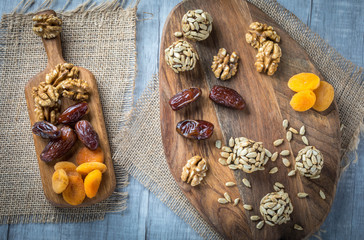 Energy protein balls with healthy ingredients. Home made with dried apricots, dates, plum, almonds, walnuts, sunflower seeds covered with cocoa powder, sesame, coconut flakes