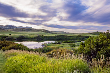 Obraz premium Mountain meadow with lake and clouds