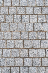 Granite paving stones on a sidewalk or pavement textured paving background. Close up top view