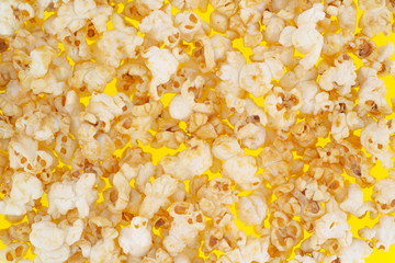 Sweet popcorn on a yellow background close-up top view