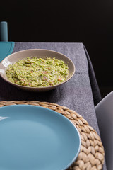 Green guacamole Mexican sauce food on a plate with bread toast slices close up still no a dark dinning table