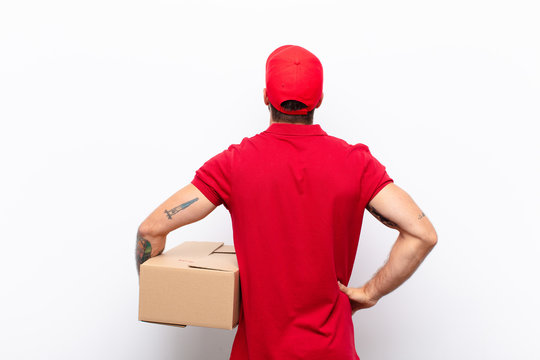 feeling confused or full or doubts and questions, wondering, with hands on hips, rear view. delivery concept