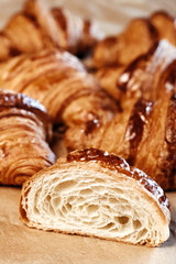 Many fresh croissants on wooden board.