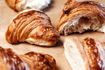 Many fresh croissants on wooden board.
