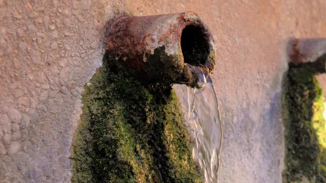 Ca&ntilde;o de barro de fuente soltando agua en c&aacute;mara lenta