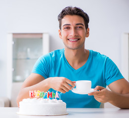 Young man celebrating birthday alone at home