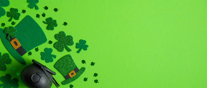 St Patrick's Day banner design. Irish elf hats, pot of gold and shamrock leaf clovers on green background with copy space. Happy Saint Patricks Day concept