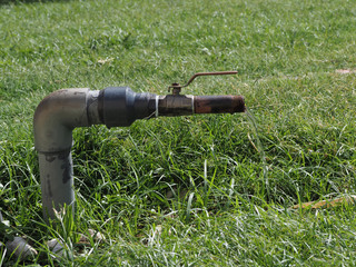 old hose connection for watering lawn flowers and grass in summer