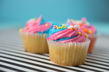 Cupcakes with blue and pink icing on a blue background