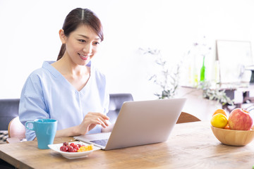 部屋でラップトップコンピューターを見る女性