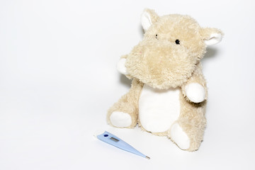 Childhood diseases concept, a teddy hippo with means for treatment fever, pain flu cough and sore throat, copy space