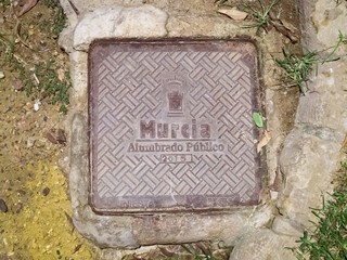 Manhole cover on pavement with patterns