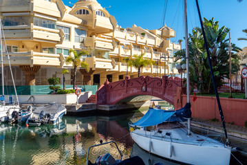 PUERTO MARINA, BENALMADENA - DECEMBER 2019: Beautiful villages surrounded with water, private port and parked yachts, Andalusia, Spain