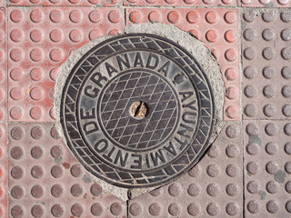 Manhole cover on pavement with patterns