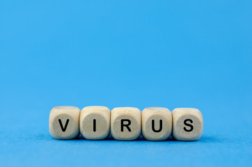 The word Virus on wooden cubes, blue background. Medical concept.