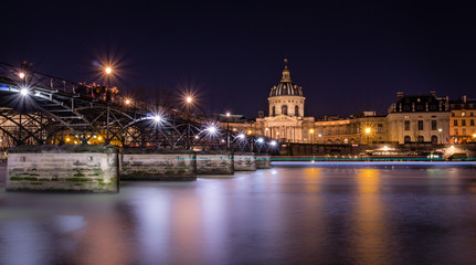 Obraz na płótnie Canvas Paris pont des Arts leading towards Institut de France, by night long exposure