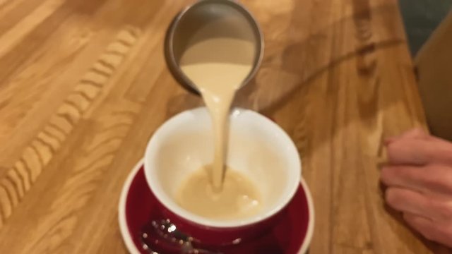 Slow motion. Barista working. The process of making coffee. Barista pours coffee with soy milk. Vegan lactose free drink. Concept of art, energy, love, passion.  Coffee 4k stock footages