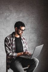 Casual man with laptop over gray background. internet, education, work, leisure
