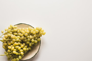 ripe green grapes in a plate isolated on white background. place for text