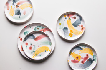 Hand-painted ceramic plates. Collection of colorful ceramic on white background