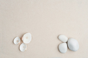 Fototapeta na wymiar set of shells and stones, colored white shells with white beach stones, with sand in the background, top view