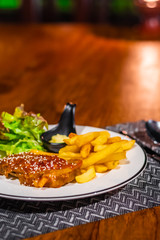 Delicious food and drink on wooden table with candle in restaurant