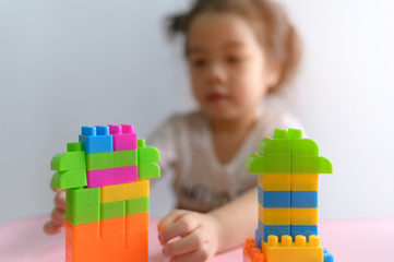 Little curly asian girl enjoy playing with toy blocks isolated on white background. Education and learning Concept.