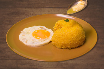 Pacman Cuscuz and egg - Traditional dish from northeastern Brazil. Cuscuz can be made from flour, corn, rice or cassava. Wood background.