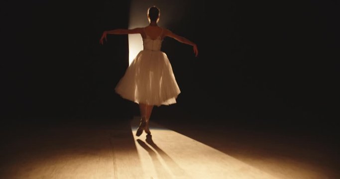 Beautiful ballet choreographer having a performance on theatre stage, dancing while spotted by bright light - arts concept 4k footage
