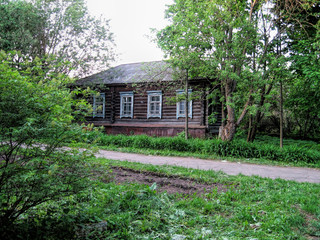 Road next to an old wooden house in summer in Russia