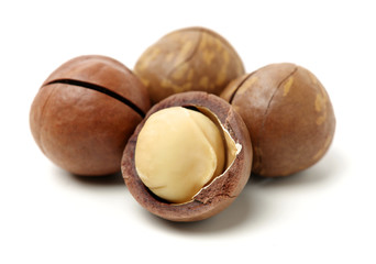 Shelled and unshelled macadamia nuts on white background 