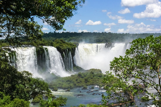 The majestic Iguazu Falls,  on the background of blue sky, one of the wonders of the world