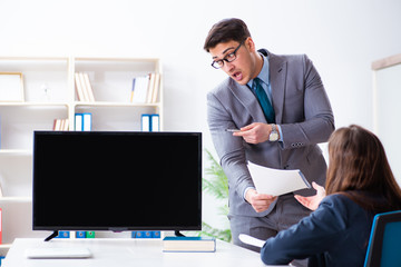Young employee making presentation to his female boss