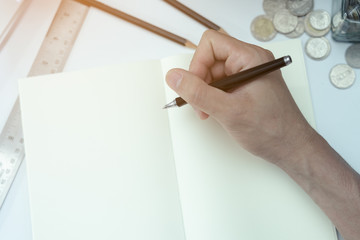  a hand writing on notebook with education equipment in top view