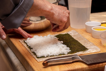 Chef preparing ingredients and teaching how to make Sushi