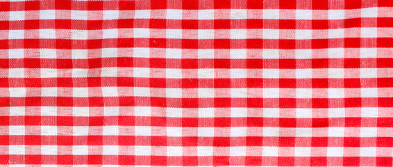 Red checkered tablecloth fabric background texture, close-up.