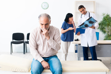 Obraz premium Old couple visiting young male doctor