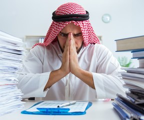 Arab businessman working in the office doing paperwork with a pi