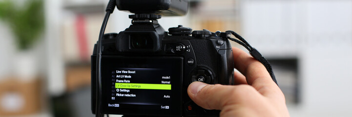 Male arms in suit mount camcorder to tripod making promo videoblog or photo session in office closeup. Vlogger adjust set up and check image quality to show job offer promotion selfie information