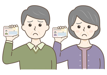 マイナンバーカードを持った高齢男女の上半身（困る）
