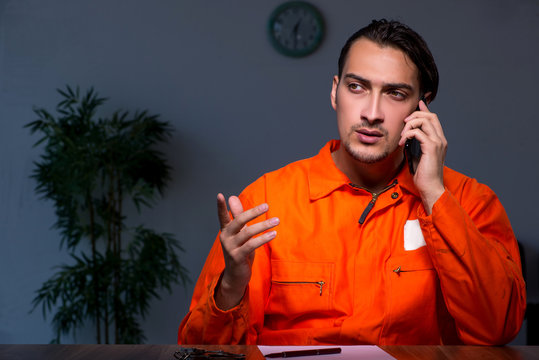 Young convict man sitting in dark room