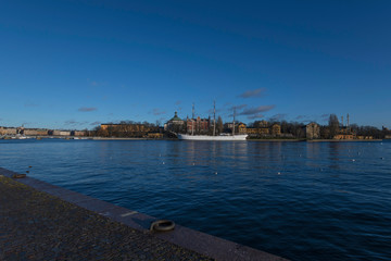 A sunny winter day in Stockholm, view over the castle Kastellet on the island Kastellhollmen with boats and parts of the old town Gamla Stan