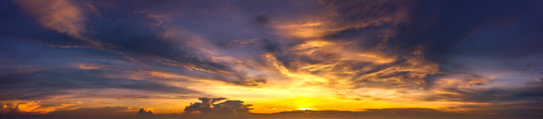Panorama Sunset with clouds, in orange and colorful shades,World Environment Day concept: Fiery orange sunset sky with dark clouds.