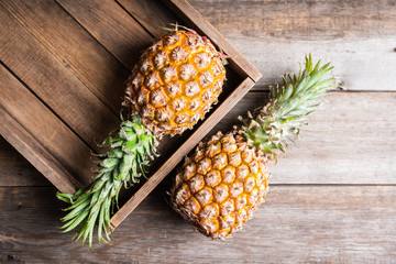 Fresh ripe pineapple in the old wooden crate. Selective focus.