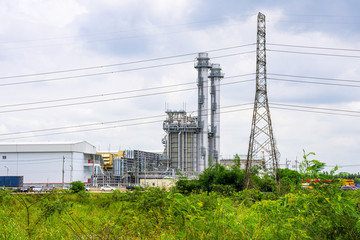 Industrial factory view at oil refinery plant with flare light from sunrise, Industrial power plant with green tree