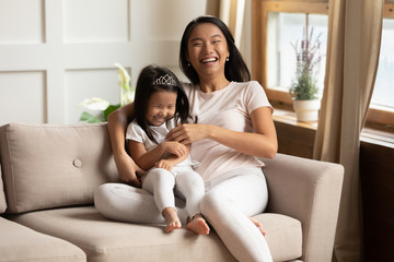 Portrait of happy Vietnamese mom and daughter playing at home