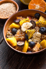 Fresh quinoa organic fruit salad in bowl on wooden  background. Helthy superfood detox concept.  Vegan/vegetarian food. Space for text. Top view