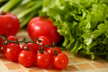 Cherry tomatoes lie on a cutting board in kitchen against backdrop of greenery healthy eating concept